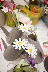 Bouquets of paper flowers inserted into decorative paper teapots. Pink, blue, yellow and white flowers. Chamomile made by hand from paper. Selective focus