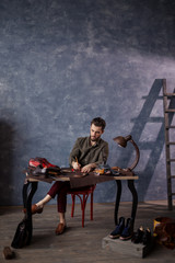 young awesome male making a draft in the leather fabric, full length photo