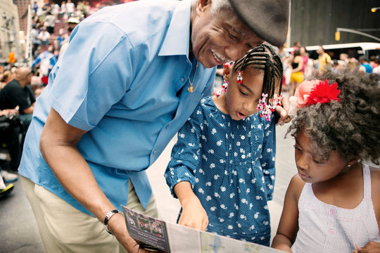 Man looking at map with two girls (4-5, 6-7) 