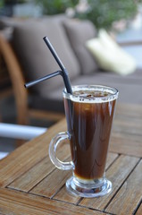 cup of cold coffee on wooden table