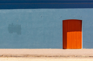 bright orange door in a  blue wall