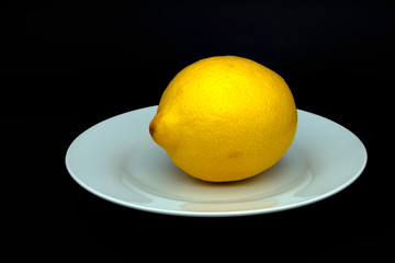 Lemon fruit (Citrus limon) on the white plate