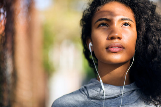 Young woman listening to music in park 