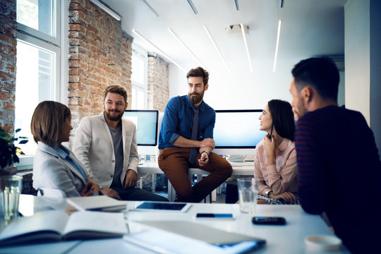 Five people talking in office 