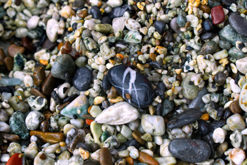 Macro image of colorful pebbles on a beach in Italy