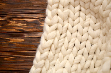 Cozy white scandinavian bedroom interior. Beautiful merino woolen plaid decorated bed and floor, super chunky yarn knitted blanket