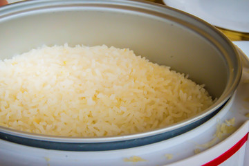Cooked jasmine rice in the electric rice cooker pot and ready to serve and eat.