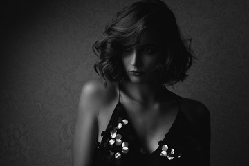 Black and white portrait of sad brunette woman with naked shoulders. Empty space