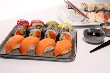 close up of sashimi sushi set with chopsticks and soy - sushi roll with salmon and sushi roll with smoked eel
