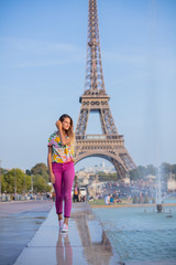 Happy girl walking in centre of Paris. Background of Eiffel tower. Travel concept