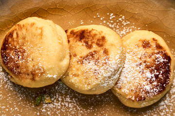Homemade Cottage cheese pancakes, syrniki on rustic wooden table, close-up