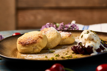 Homemade Cottage cheese pancakes, syrniki on rustic wooden table, close-up