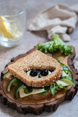 Funny spider sandwich with black cheese and olives for Halloween party, scary food