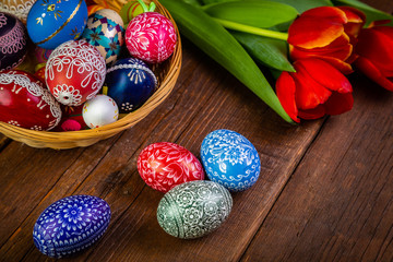 Easter eggs with tulips on weathered wooden background