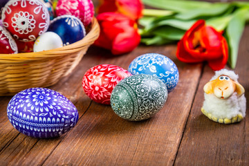 Easter eggs with tulips on weathered wooden background