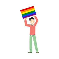 A young smiling white brunet man and gay in pants and sweater holds a poster or a banner with a rainbow.