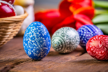 Easter eggs with tulips on weathered wooden background