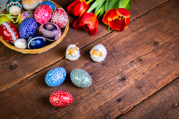 Easter eggs with tulips on weathered wooden background