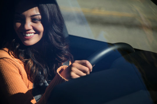 Young smiling woman driving car 
