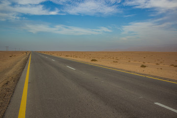 picturesque scenery desert landscape with yellow sand wilderness environment and asphalt empty highway car road, infrastructure and transportation concept photography, copy space