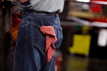 View of man wearing jeans in factory, mid section, 