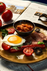 Full English breakfast with bacon, sausage, fried egg, baked beans