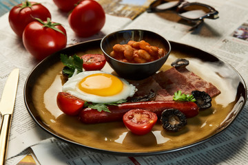 Full English breakfast with bacon, sausage, fried egg, baked beans