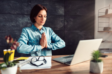Business woman meditating at work