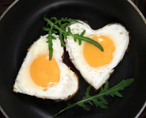 Fried eggs in the shape of a heart in a frying pan