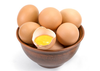 Brown chicken organic eggs in clay bowl. Isolated on white background.