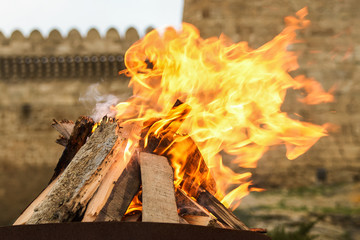 Traditional Novruz holiday bonfire with old brick palace wall as background