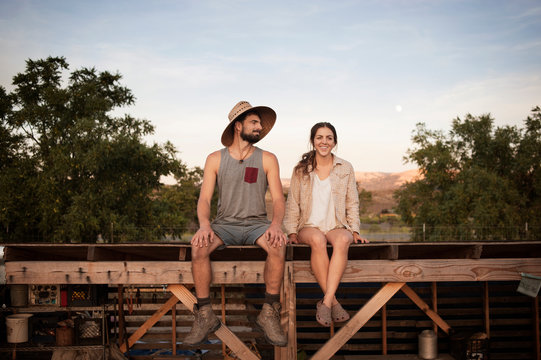 Young couple sitting on roof of shed 