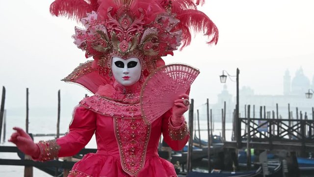 Venice - carnival masks are photographed with tourists in Piazza San Marco