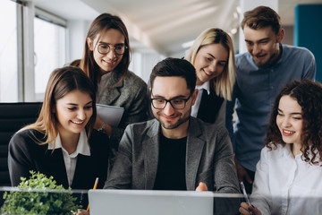 Obraz premium Working with new project. Beautiful business people are using computers and smiling while working in office.