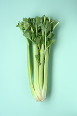 whole raw celery isolated on green background