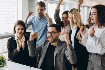 Portrait of very happy successful expressive gesturing business team at office