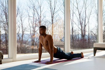 Young man exercising in living room 