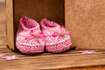 Fototapeta na wymiar decoration with pink baby shoe, wooden background