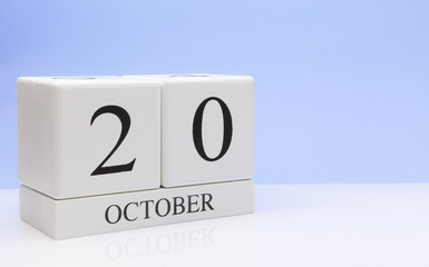 October 20st. Day 20 of month, daily calendar on white table with reflection, with light blue background. Autumn time, empty space for text