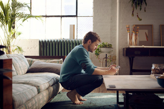 Side view of young man looking at mobile phone 