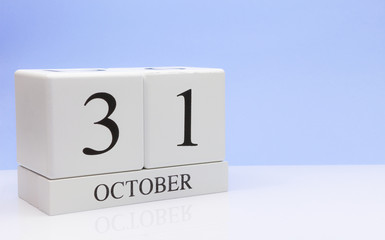 October 31st. Day 31 of month, daily calendar on white table with reflection, with light blue background. Autumn time, empty space for text