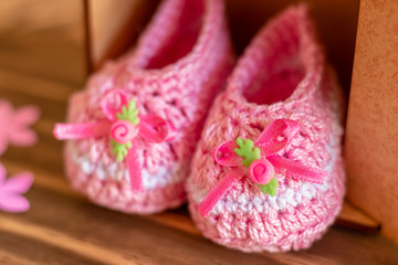 decoration with pink baby shoe, wooden background