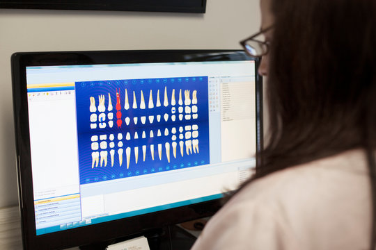 Dentist using computer to study teeth treatment 