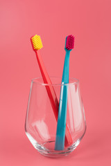 Cup with toothbrushes on table against color background. Dental care