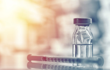 Closeup of medicine vial or flu, measles vaccine bottle with syringe and needle for immunization on vintage medical background, medicine and drug concept - obrazy, fototapety, plakaty