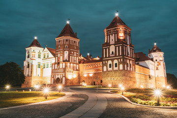 Fototapeta na wymiar Mir, Belarus. Mir Castle Complex In Evening Night Illumination Lighting. Famous Landmark. UNESCO Heritage. Architectural And Cultural Heritage.
