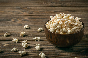 Popcorn in a bowl on an old wooden table.