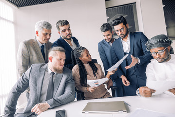 Female coach mentor teacher talking with top managers about worksheets in corporate training,...