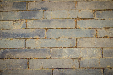 Grungy rectangular gray stone pavement for background. Top view of grey paving stone pattern, same sizes stones pavement road as background.