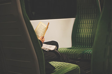 Reading a book alone on a train.